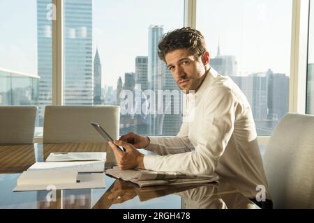 Young man using tablet PC at table in New York City Stock Photo