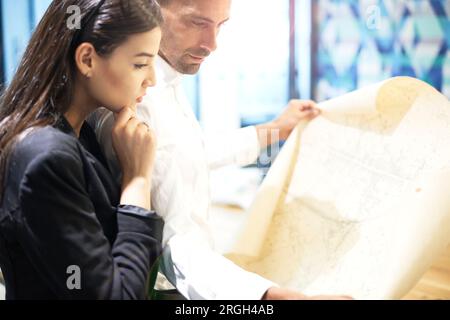 Colleagues examining blueprint Stock Photo