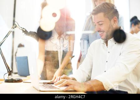 Young businessman using laptop at desk Stock Photo