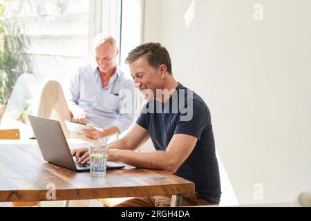 Mature couple using laptop and digital tablet Stock Photo