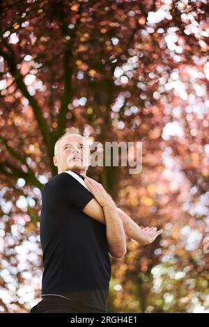 Mature man practicing yoga in park Stock Photo