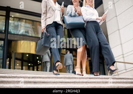 Businesswomen walking down staircase Stock Photo