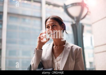 Young woman smiling while on phone Stock Photo