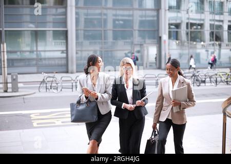 Businesswomen walking on sidewalk Stock Photo