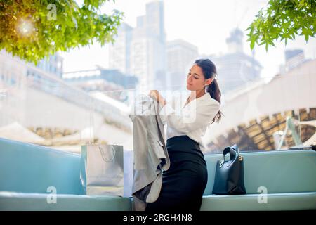 Businesswoman putting on blazer Stock Photo