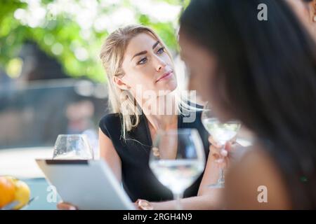 Businesswomen using digital tablet at restaurant Stock Photo
