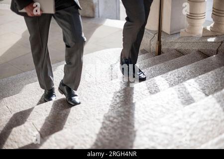 Men walking up staircase Stock Photo