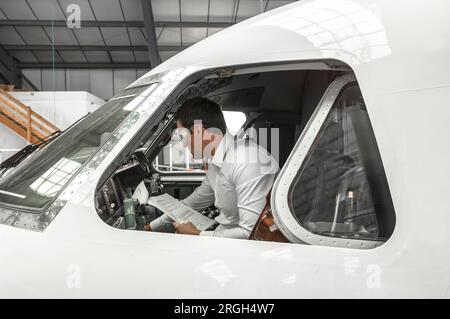 Pilot in cockpit in hangar Stock Photo