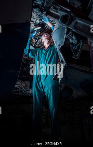 Man working on airplane in shadow Stock Photo