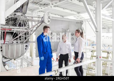 Workers with digital tablet in airplane hangar Stock Photo