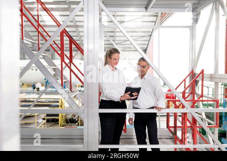 Businesspeople using digital tablet on staircase Stock Photo
