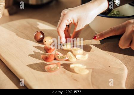 Woman's hands chopping tomatoes Stock Photo