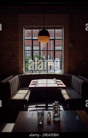 Tables and chairs in a restaurant, plain white walls and grey flooring ...