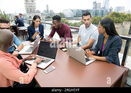 Businesspeople with laptops during meeting on balcony Stock Photo