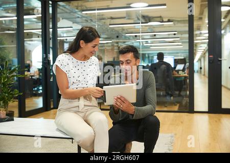 Colleagues using digital tablet in office Stock Photo