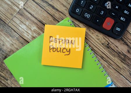 Concept of Return Policy write on sticky notes isolated on Wooden Table. Stock Photo