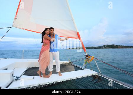 Young couple embracing on yacht at sunset Stock Photo