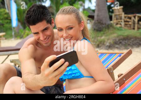 Young couple taking selfie on beach Stock Photo