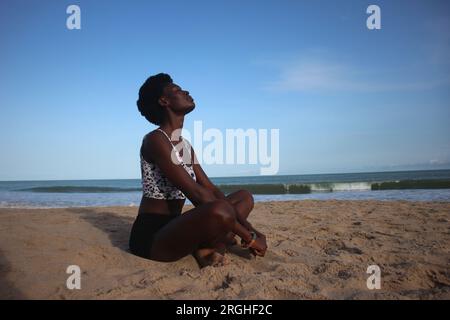 Sandy Asana: Beach side Yoga Pose of an African Woman Stock Photo - Alamy