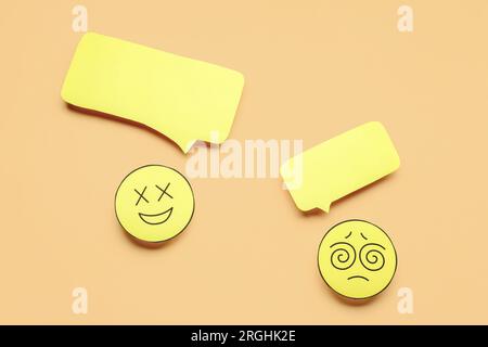 Paper faces with blank speech bubbles on beige background Stock Photo