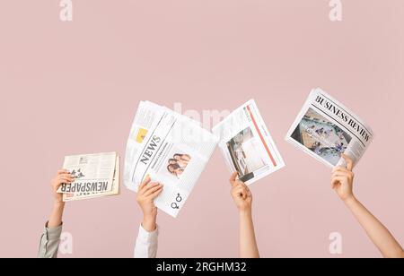 Female hands with different newspapers on color background Stock Photo