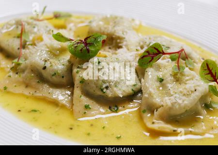 Italian food, mushroom stuffed ravioli pasta with creamy parmesan cheese sauce in a white plate Stock Photo