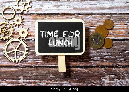 Stationery, tasty food in lunchbox and notebook with text TIME TO LUNCH on grunge blue background Stock Photo