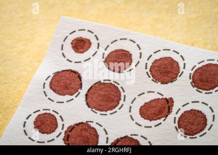 dry blood spots on a fiber filter for laboratory analysis, home health testing concept Stock Photo