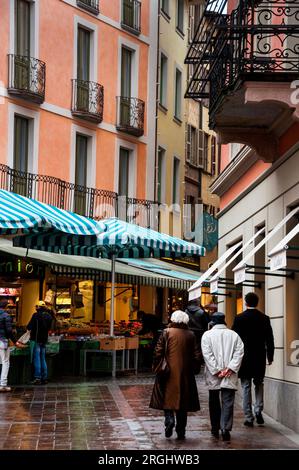 Colorful townhouses and a weekly farmers market in the old town pedestrian zone of Lugano, Switzerland. Stock Photo