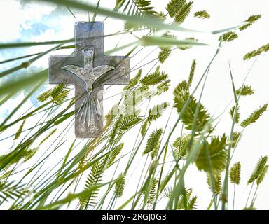 This composite shows looking above to the sky and seeing a cross with the Holy Spirit, a Christian symbol of faith in the world. Stock Photo