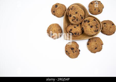 Chocolate chip cookies on a heart shaped plate on a white background Stock Photo