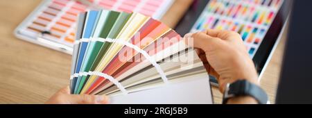 Two designers looking at many color samples discussing about colors for new projects. Stock Photo