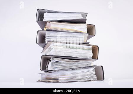 stack of black file folders full of documents against white background, space for your text Stock Photo