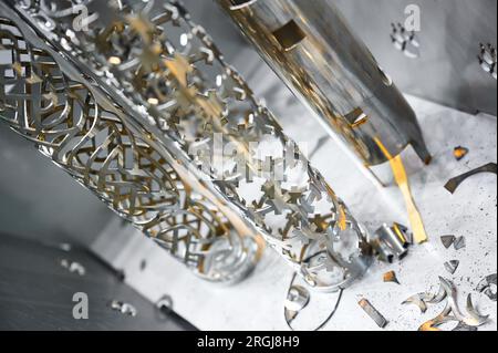 Metal pipes processed with laser cutting machine in shop Stock Photo