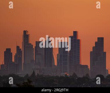 Wimbledon, London, UK. 10th Aug, 2023. Temperatures in London due to peak at a pleasant 25 degrees today. An orange sky at sunrise with the skyscrapers of central London catching the first rays of sunlight. Credit: Malcolm Park/Alamy Live News Stock Photo