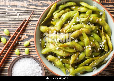 Stir-fried green soy beans edamame seasoned garlic and salt closeup on the plate on the table. Horizontal top view from above Stock Photo