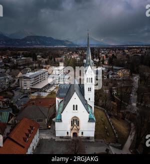 Bled, Slovenia - Aerial panoramic view of St. Martin's Parish Church with Julian Alps at the background on a cloudy winter afternoon Stock Photo