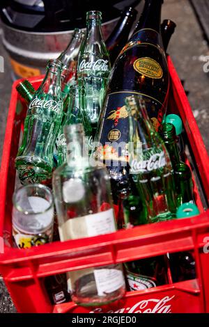 Empty Coca-Cola bottles and other bottles in a red Coca-Cola plastic crate; Japan Stock Photo