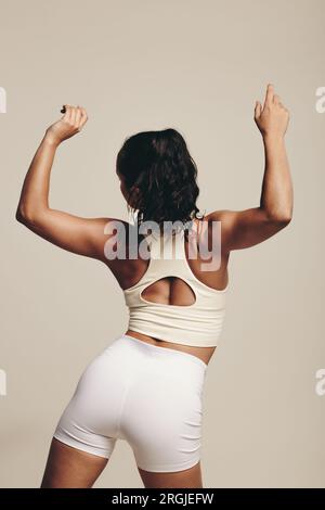 Young female athlete training in a studio, she is showcasing her strength, balance and flexibility through her body movement. Fit young woman stretchi Stock Photo