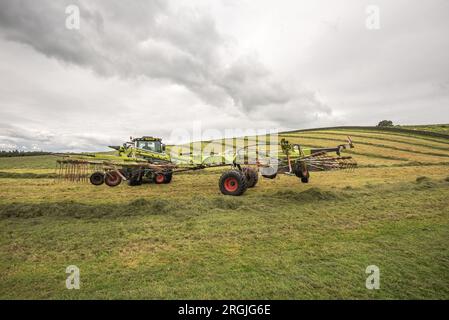 Tractor rowing up during silage making at Little Newton Long Preston, near Hellifield, Yorkshire Dales during a brief weather window, Stock Photo