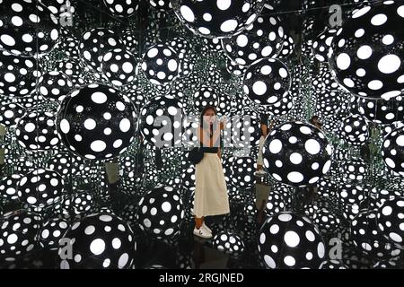 Hong Kong. August 10, 2023, Hong Kong, Hong Kong, Hong Kong: A woman takes pictures inside the art installation ''” DOTS OBSESSION ''“ ASPIRING TO HEAVEN'S LOVE, at M Visual Culture Museum in The artwork by Japanese artist Yayoi Kusama, who has lived in the United States between 1958 and 1975, features her famous polka dots and reflective mirrors inside a cubic environment which offers a kaleidoscopic visual experience. (Credit Image: © Daniel Ceng Shou-Yi/ZUMA Press Wire) EDITORIAL USAGE ONLY! Not for Commercial USAGE! Credit: ZUMA Press, Inc./Alamy Live News Stock Photo