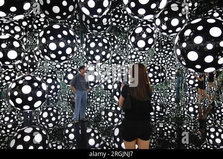 Hong Kong. August 10, 2023, Hong Kong, Hong Kong, Hong Kong: People take pictures inside the art installation ''” DOTS OBSESSION ''“ ASPIRING TO HEAVEN'S LOVE, at M Visual Culture Museum in The artwork by Japanese artist Yayoi Kusama, who has lived in the United States between 1958 and 1975, features her famous polka dots and reflective mirrors inside a cubic environment which offers a kaleidoscopic visual experience. (Credit Image: © Daniel Ceng Shou-Yi/ZUMA Press Wire) EDITORIAL USAGE ONLY! Not for Commercial USAGE! Credit: ZUMA Press, Inc./Alamy Live News Stock Photo