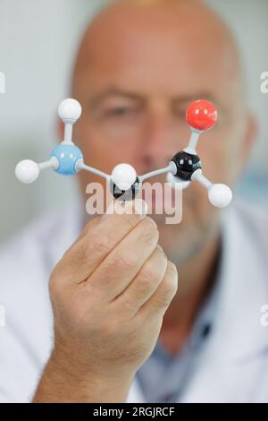 plastic model molecule held by senior male scientist Stock Photo