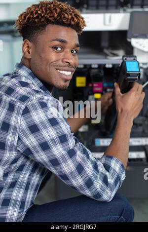 technician using a tablet to fix a printer Stock Photo