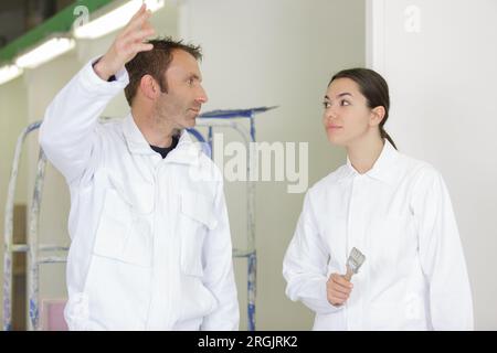 a painter with an young woman apprentice Stock Photo