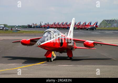 Former RAF jet trainer Red Gnat Display Team Folland Gnat T1 taxiing out at Biggin Hill with Royal Air Force Red Arrows Hawk jets lined up beyond Stock Photo