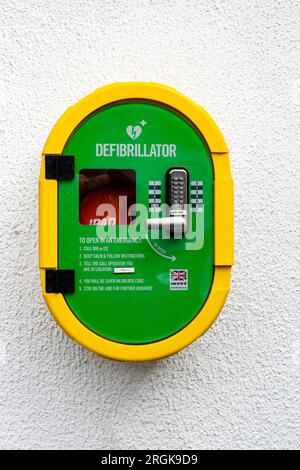Portait  view against a white wall of an Automated external defibrillator, or AED kept where health professionals and first responders can use them Stock Photo