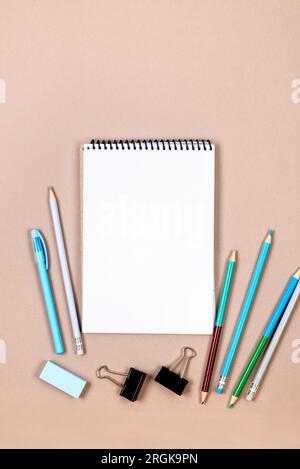 School notebook and various stationery for boys in blue on beige background. Supplies for studying at school. Flatlay,  mock up. Frame of colorful sta Stock Photo