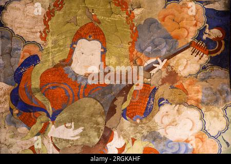 India, Ladakh, Zanskar, Bardan Monastery, small Prayer Hall interior, man playing dramyen wall painting Stock Photo