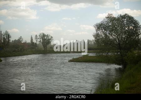 Wind on lake. Weather changes in summer. Waves on water. Pond in city. Storm warning. Stock Photo